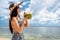 Woman tourist drinking coconut milk at beach in holidays