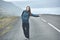 A woman tourist on the empty road on the fjord in Iceland