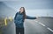 A woman tourist on the empty road on the fjord in Iceland