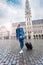 Woman tourist goes with a suitcase at the Grand Place in Brussels, Belgium