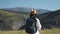 Woman tourist hiking in the mountains, walking to the top, back view.