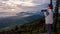 Woman tourist holding a DSLR camera looking at the beautiful nature landscape of sun fog mountain in the winter during sunrise on