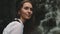 Woman tourist near splashing waterfall portrait