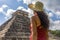 Woman tourist observing the old pyramid and temple of the castle of the Mayan architecture known as Chichen Itza