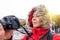 Woman tourist or photographer in a winter jacket with a camera on the street