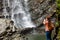 Woman tourist photographs a waterfall