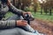 Woman tourist pours hot tea out of thermos in autumn forest. Camping, traveling and sport concept