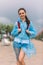 Woman tourist in raincoat with backpack smiling