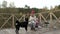 A woman tourist sits on the bridge near the river bank, feeds the dog, cooks food, picnic, active rest and healthy