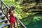 Woman tourist on the stairs of the subway cenote Saamal of chichen itza is in the Mayan jungle hacienda of the Yucatan Peninsula