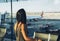 Woman tourist standing with luggage watching window at airport waiting his flight