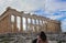 Woman tourist takes picture of the Parthenon in Athens with a tablet against blue sky with clouds
