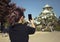 woman tourist taking a photo of osaka castle by smart phone,osaka castle is one of most popular traveling destination in japan