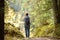 Woman tourist taking photo of scenic view of the forest in National Park Durmitor on autumn day. Hiking and travel