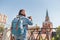 Woman tourist taking pictures on mobile phone on the backgroung the Kremlin wall tower. Travel to Russia concept