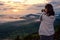 Woman tourist are using a DSLR camera photographing nature landscape the sun fog mountain in the winter during sunrise on high