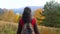 Woman tourist walking in fall forest on sunny autumn day. Hiker traveler woman hikking on mountain, enjoying panoramic