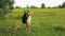 A woman tourist walks through a forest glade and looks through binoculars where to go next.