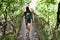 Woman tourist walks on a suspension bridge on nature in a tropical forest. dangerous wooden bridge in the jungle