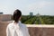 Woman toursit standing on building rooftop enjoying seeing panoramic view