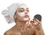 Woman in towel doing cosmetic mask