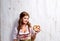 Woman in traditional bavarian dress holding pretzel, wooden back