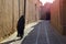 A woman in traditional black Islamic clothing walks the empty morning street of the eastern city.