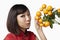 Woman in traditional clothing posing with a bouquet of kumquat. Conceptual image