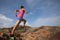 Woman trail runner running to rocky mountain top on seaside