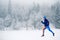 Woman trail running on snow in winter mountains