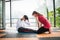 Woman trainer help sportsman sit ups in gym