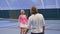 Woman-trainer shows player how to hit the tennis ball