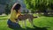 woman is training her dog in park at summer morning