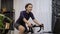 Woman is training indoor on smart bike trainer. Female is cycling on bicycle simulator