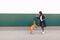 Woman trains a dog against the background of the wall. Walking with a dog in the city