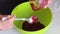 A woman transfers cranberries cooked with sugar from a saucepan into a colander. Prepares mashed potatoes for marshmallow.