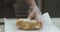 Woman in transparent gloves preparing tuna salad sandwich in local fast food