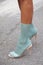 Woman with transparent high heel shoes and pale blue socks before Fila fashion show, Milan