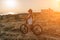 Woman travel bike. Happy woman cyclist sitting on her bike, enjoying the beautiful mountain and sea landscape