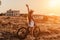 Woman travel bike. Happy woman cyclist sitting on her bike, enjoying the beautiful mountain and sea landscape