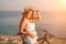 Woman travel bike sea. Happy woman cyclist sitting on her bike, enjoying the beautiful mountain and sea landscape