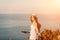 Woman travel bike sea. Happy woman cyclist sitting on her bike, enjoying the beautiful mountain and sea landscape