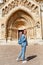 Woman traveler with backpack admiring tourist sights and destinations in Europe. Jaki chapel in Vajdahunyad castle in