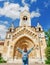 Woman traveler with backpack admiring tourist sights and destinations in Europe. Jaki chapel in Vajdahunyad castle in