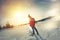 Woman traveler with a backpack looks at his tracks in the snow