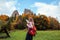 Woman traveler with backpack pointing on rocks of Tustan in autumn Carpathian mountains. Tourism in Ukraine