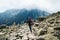 Woman traveler backpack tracking sticks top mountain Mount Rysy