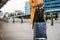 Woman traveler in coat with handbag and suitcase orders taxi