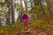 Woman traveler descends from a hill in the autumn forest