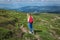 Woman traveler, girl with backpack walking mountains summer outside